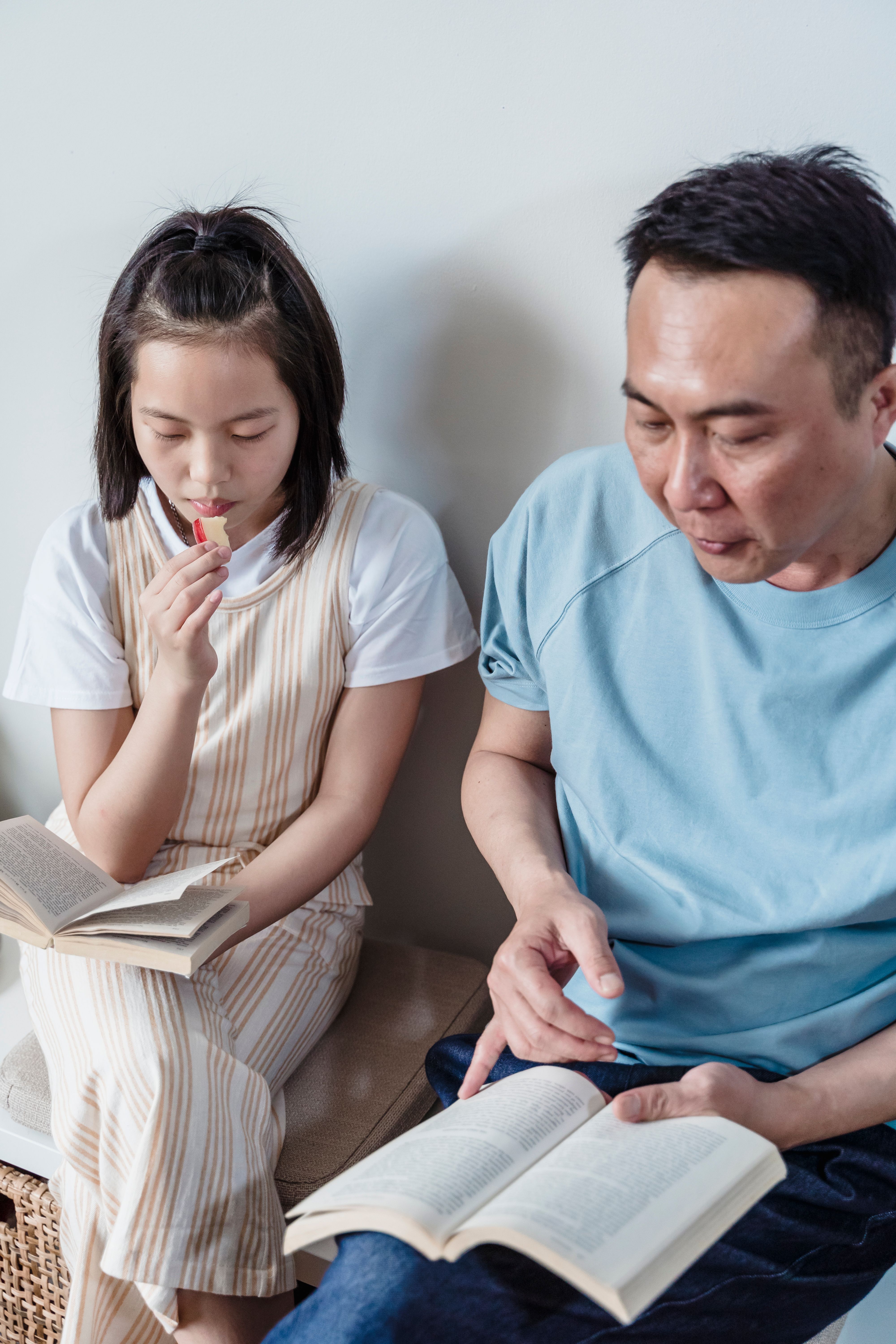 Father and daughter sharing books together, representing intergenerational learning and mutual respect